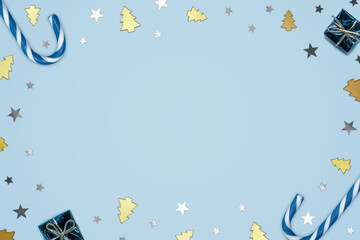 Naklejka na ściany i meble Blue Candy Canes, Deco Glass Trees, Mini Foil Presents and Metallic Star Confetti Frame on Light Blue Background
