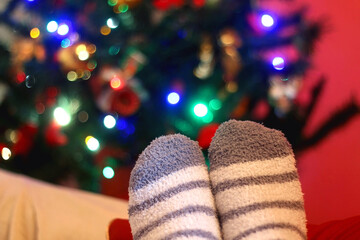 Feet in fluffy socks resting on the sofa. Selective focus.