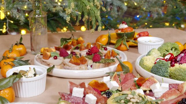 Festive table with delicious appetizers with cheese, prosciutto, fresh fruits and berries. Healthy eating. Background