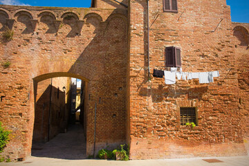 The entrance and part of the town walls of the historic medieval village of Buonconvento, Siena Province, Tuscany, Italy
