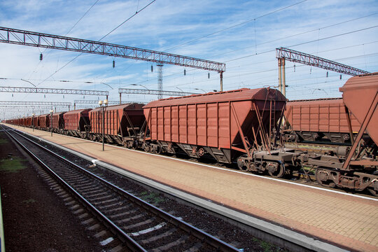 grain carrier freight car for transportation of bulk cargo of grain crops, railway track with rails and wagons going into perspective, background on theme of transportation and export of grain nobody.