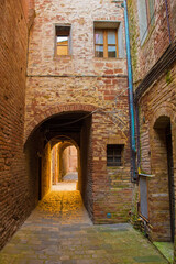 Fototapeta na wymiar A quiet residential back street in the historic medieval village of Buonconvento, Siena Province, Tuscany, Italy 