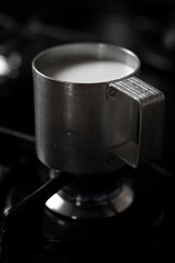 Heating milk in a rustic metal mug, Povoa de Lanhoso, Braga, Portugal.