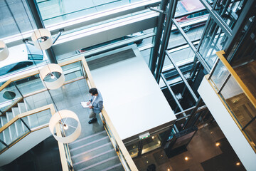 Unrecognizable male manager standing on stairs with paper holder