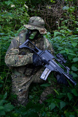 Croatia recon forces soldier camouflaging in the forest with the 
Cropat woodland uniform and assault rifle.