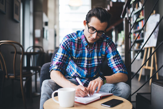 Focused writer taking notes in notebook