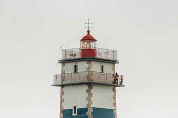 Fototapeta na wymiar Lighthouse tower at the sunset. Santa Marta Lighthouse in Cascais, Portugal 