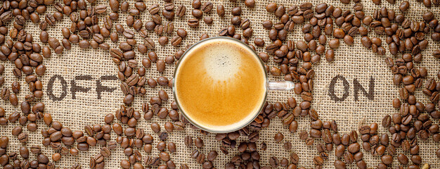 close up coffee cup and coffee beans on a table with signs on and off