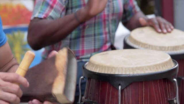 Two man playing percussion instruments in Conde Santo Domingo, close-up shot