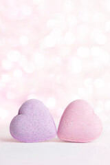 Obraz premium Vertical Valentines day greeting card , 2 pastel pink hearts on gentle pink background with bokeh and place for text