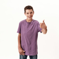 Happy teenaged disabled boy with cerebral palsy smiling and showing thumbs up at camera, posing isolated over white background