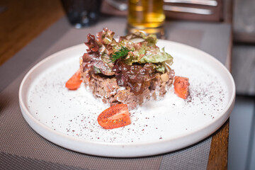 Meat and greens salad with tomatoes on a beautiful plate