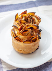 Handmade cinnamon and apple buns on a white plate.