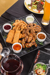 Various deep fried beer snack and chicken wings on the table at restaurant