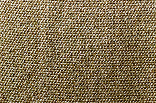 Closeup shot of knitted capron throw knit rough texture. Beige fabric with square patterns