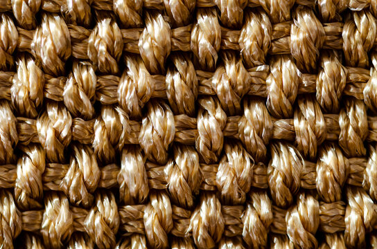 Closeup shot of knitted capron throw knit rough texture. Beige fabric with square patterns