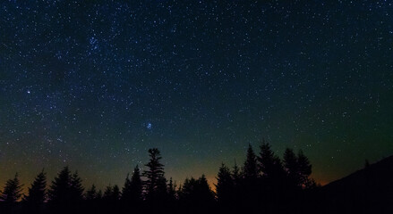 Fototapeta premium Fantastic starry night with galaxy Milky Way with a tourist and a tent on the mountain range in the Ukrainian Carpathians 