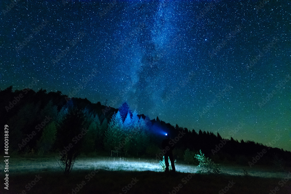 Wall mural fantastic starry night with galaxy milky way with a tourist and a tent on the mountain range in the 