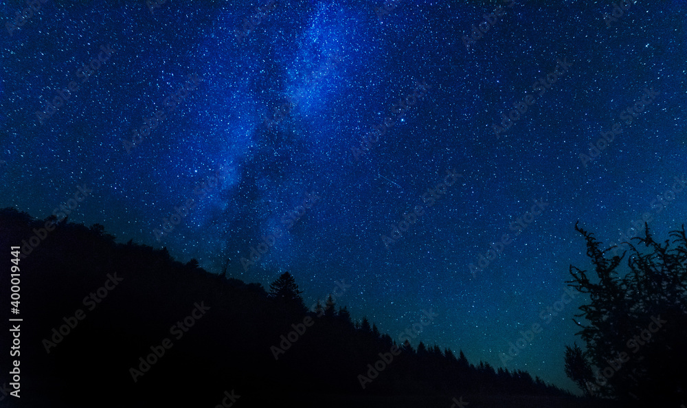 Wall mural fantastic starry night with galaxy milky way with a tourist and a tent on the mountain range in the 