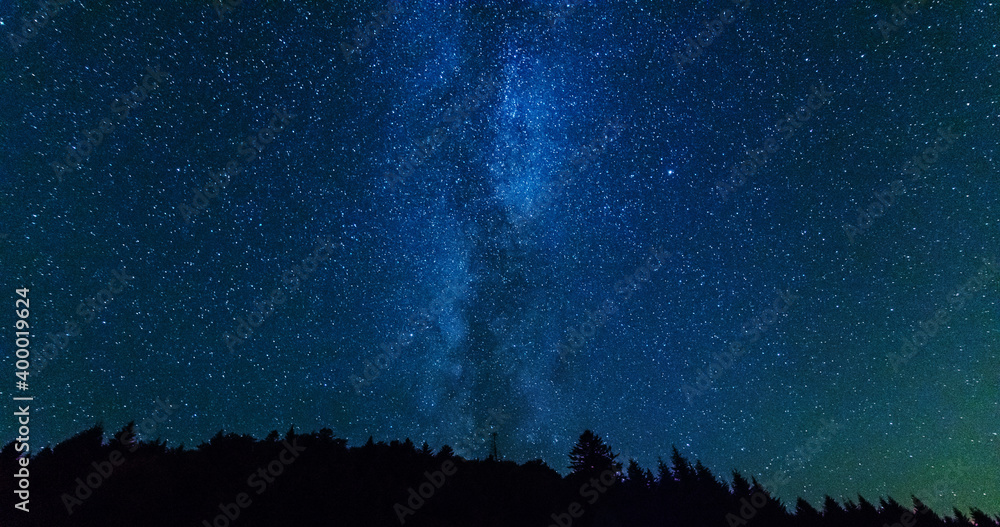 Wall mural fantastic starry night with galaxy milky way with a tourist and a tent on the mountain range in the 