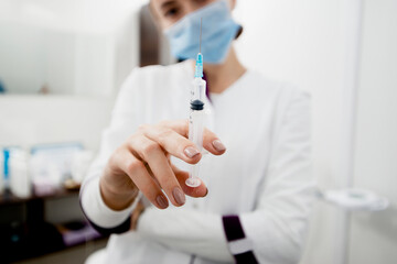Young white doctor with syringe is ready to make injection