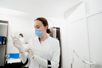 Fototapeta premium Young white cosmetologist is preparing to checkup her patients
