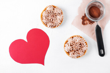 Small Banoffee pie, ground coffee and paper heart on the white table. Flat lay with dessert for Valentine's Day