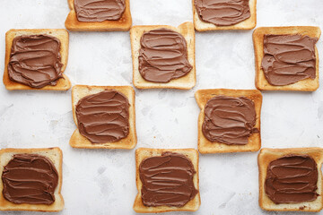 Toasted bread with chocolate-nut paste spread decomposition staggered top view