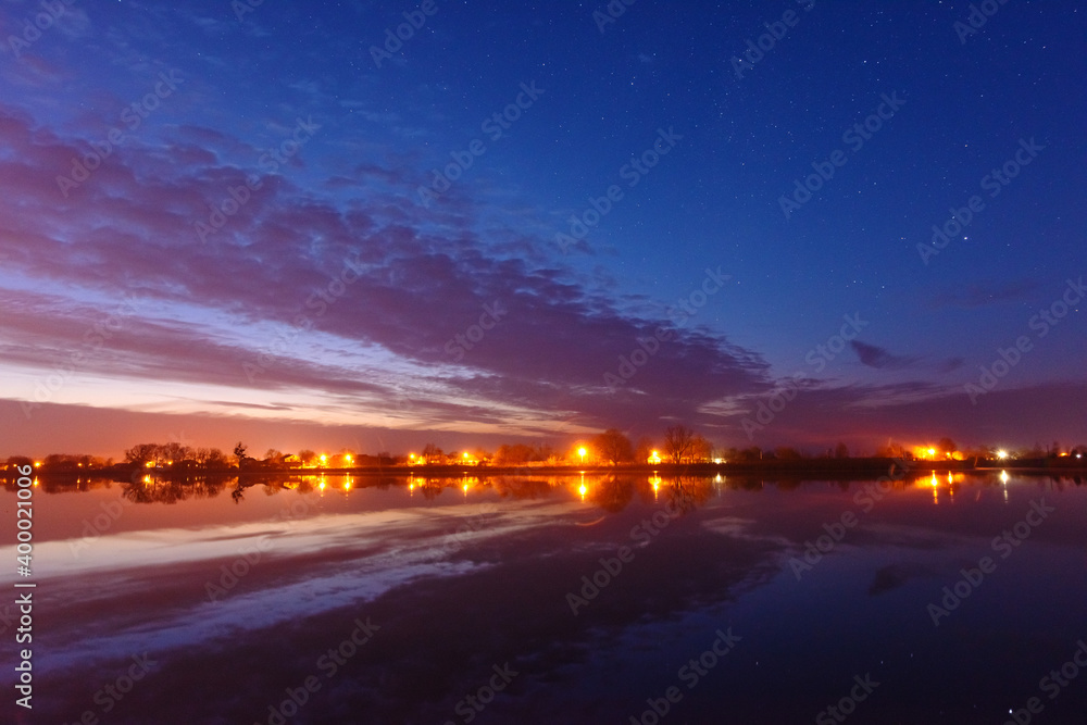 Wall mural a magical starry night on the river bank with a large tree and a milky way in the sky and falling st
