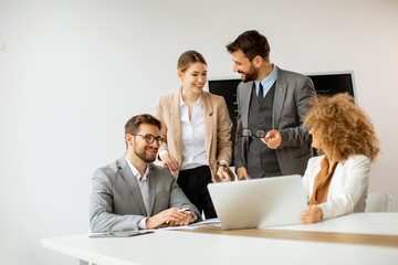 Group of young business people working and communicating while sitting at the office desk together