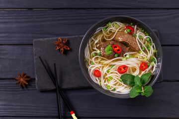 Pho Bo - Vietnamese fresh rice noodle soup with beef, herbs, lime and chili. Vietnamese national...