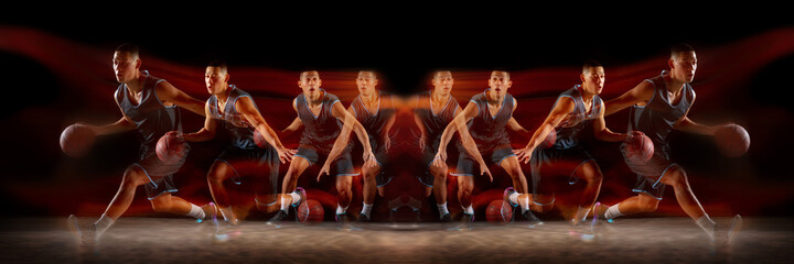 Young purposeful basketball player training in action on black background with fire flames. Mirror,...
