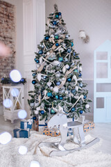 Christmas and New Year decorated interior room with presents and New year tree and toy wooden deer close up. Copy space