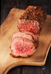 roast beef with salt and pepper on a wooden board