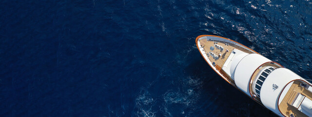 Aerial drone ultra wide photo of luxury yacht with wooden deck anchored in Mediterranean deep blue sea, Greece - obrazy, fototapety, plakaty