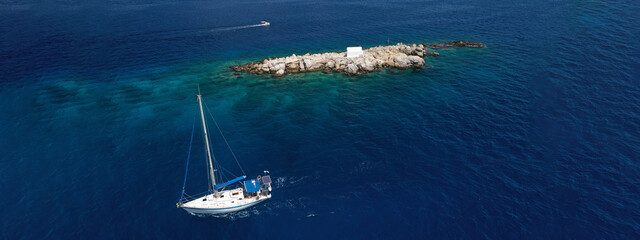 Aerial drone ultra wide photo of small picturesque chapel of Agios Nikolaos built in small islet...
