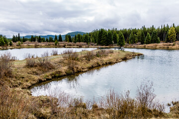 Obraz premium The still waters of Elk Pond. Elk Creek Fish Pond Provincial Recreation Area, Alberta, Canada