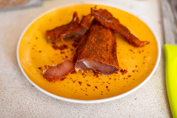 jerky chicken with spices, sliced on a plate.