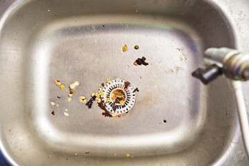 dirty sink with food leftovers. blockage sink with tap