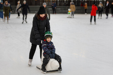 Mom and son skate on the ice rink