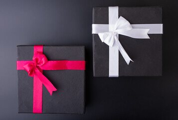 black gift boxes with white and red ribbons top shot flay lay black background 
