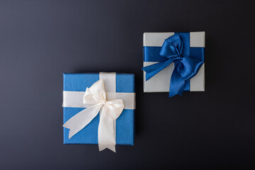 blue and white ribbon gift boxes top shot flat lay black background