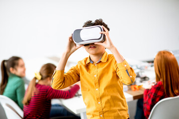 Cute little boy wearing VR virtual reality glasses