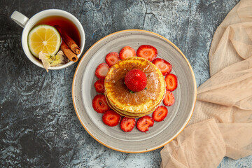 top view yummy pancakes with cup of tea and fruits on a light background cake sweet fruits