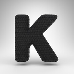 Letter K uppercase on white background. Black carbon fiber 3D letter with carbon thread texture.
