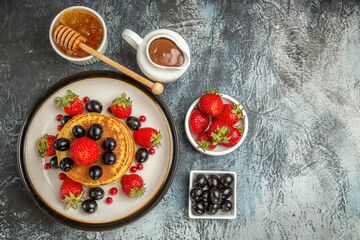Fototapeta na wymiar top view yummy pancakes with honey and fruits on the light background fruit cake sweet