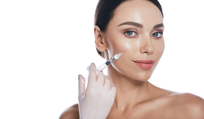 Beautician doing injections dermal fillers into female cheeks for a younger or more beautiful face....