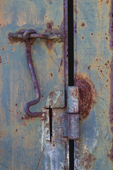 Rusty hook on a metal door.