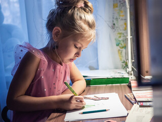 girl drawing dress for paper doll