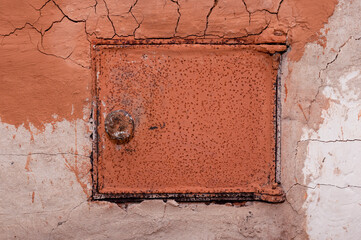 Old shabby and rusty metal door of brick furnace in country house